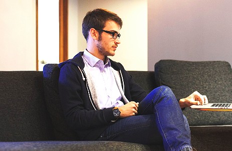 Mann arbeitet am Sofa mit seinem Laptop